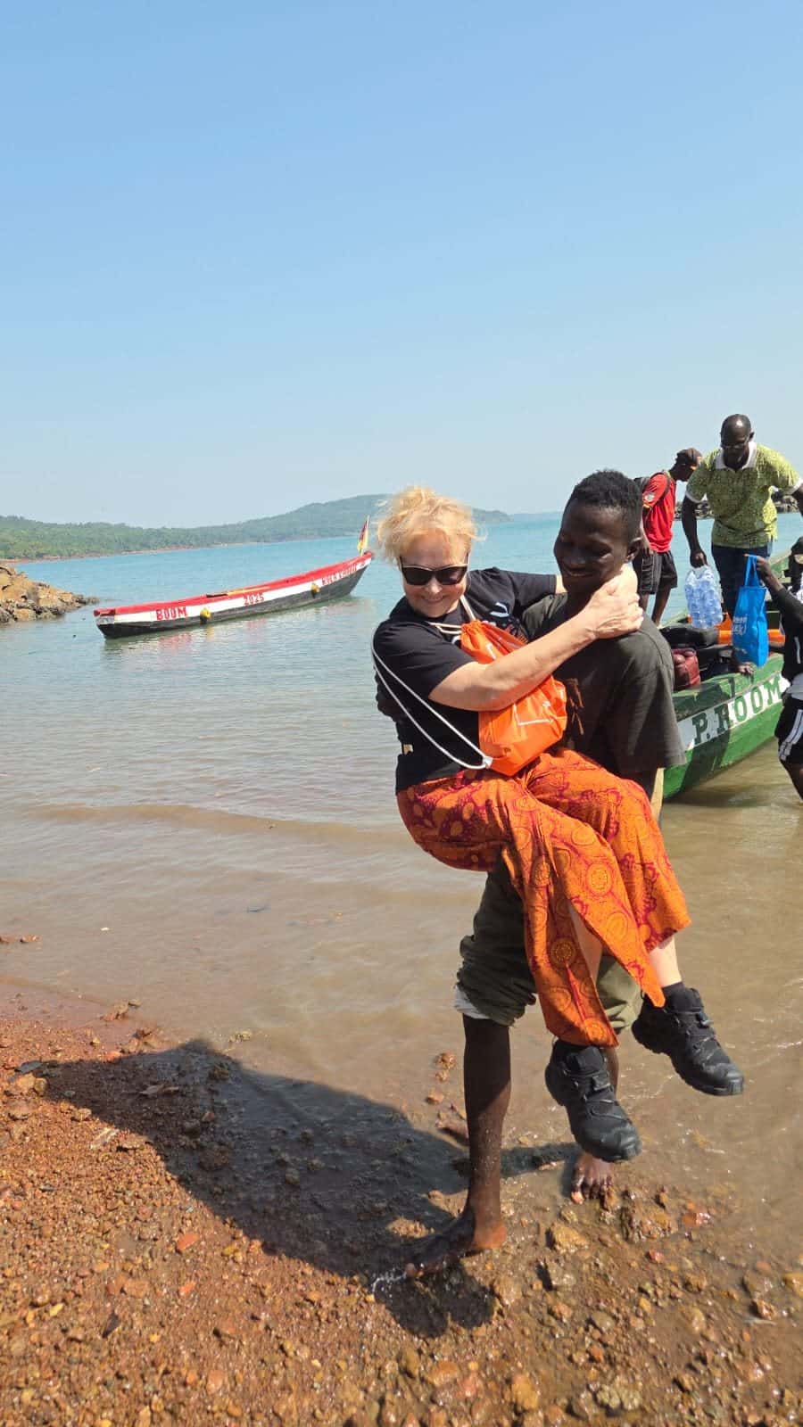 A traveller helped ashore from a boat